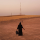 An Iraqi woman walks in a field beside a temporary displacement camp for Iraqis caught-up in the fighting in and around the city of Mosul on June 24, 2014 in Kalak, Iraq. Photo via Getty.